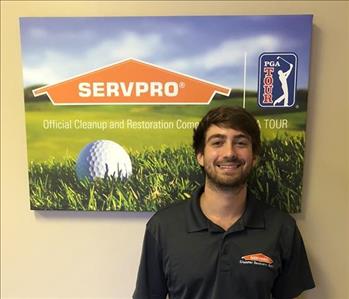 Male employee smiling in front of SERVPRO PGA Tour Photo