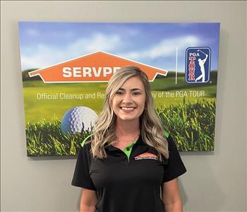 A female SERVPRO employee is shown in a black shirt with SERVPRO logo