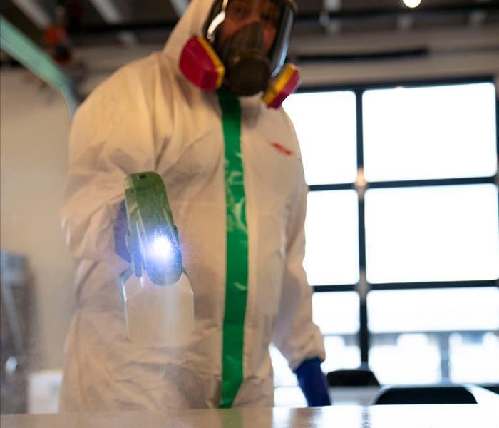 SERVPRO tech sprays to disinfect surface